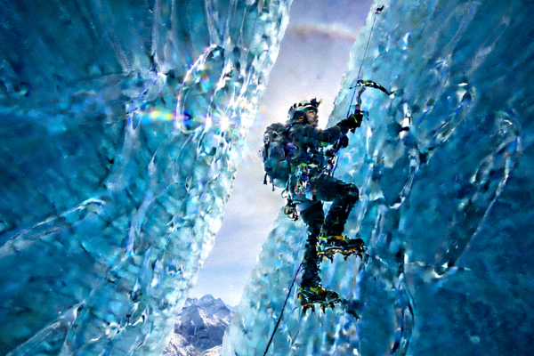 攀冰爱好者在巨大的蓝色冰瀑上进行技术攀登